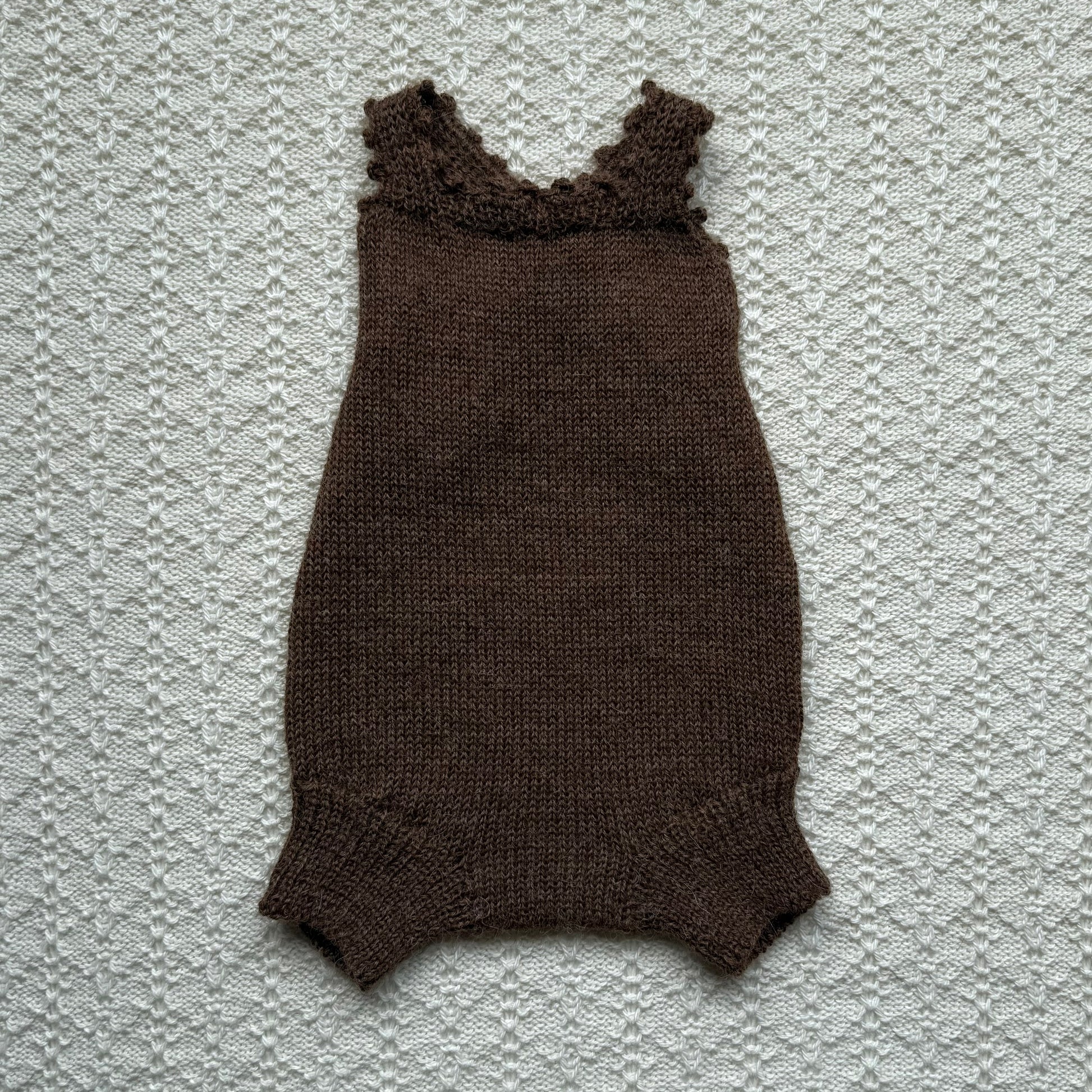 Chocolate Poppy plain knit newborn romper with crochet straps front